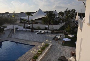 A rooftop pool area with lounge chairs, a swimming pool, and a white tent-like structure. - Female Resort (San Felice Circeo)