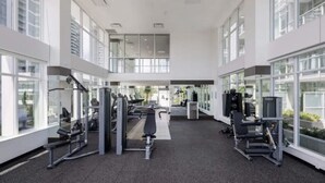 Een moderne sportschool met diverse fitnessapparaten, grote ramen en een ruim interieur.