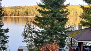 A lakeside cabin with a dock and a covered outdoor seating area.