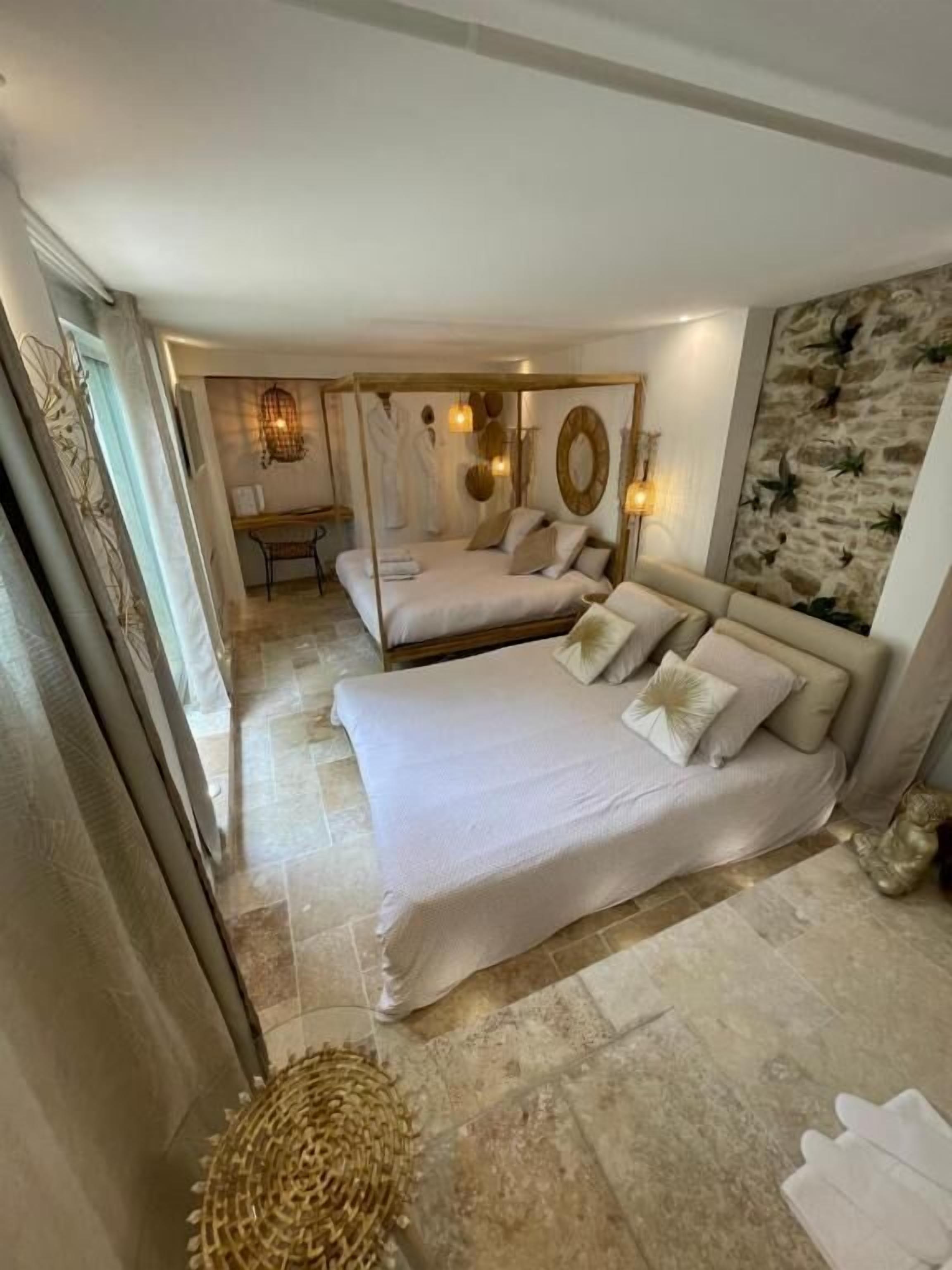 A bedroom with a large bed, a smaller bed, a desk, and a chair.