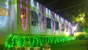 A building with string lights and potted plants. - Hotel Ambika Palace by Shiwani Associate (Agra)