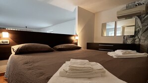 A hotel room with a large bed, a flat-screen TV, and a wall-mounted air conditioner. - Loft in downtown Milan, cozy, quiet 15 minutes from p.zza Duomo. (Milano)