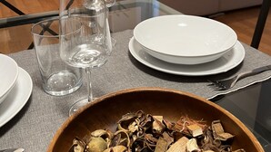 A dining table set with plates, glasses, and a bowl of dried mushrooms. - Loft in downtown Milan, cozy, quiet 15 minutes from p.zza Duomo. (Milano)