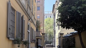 A narrow alleyway with buildings on either side, a paved walkway, and a small grassy area. - Loft in downtown Milan, cozy, quiet 15 minutes from p.zza Duomo. (Milano)