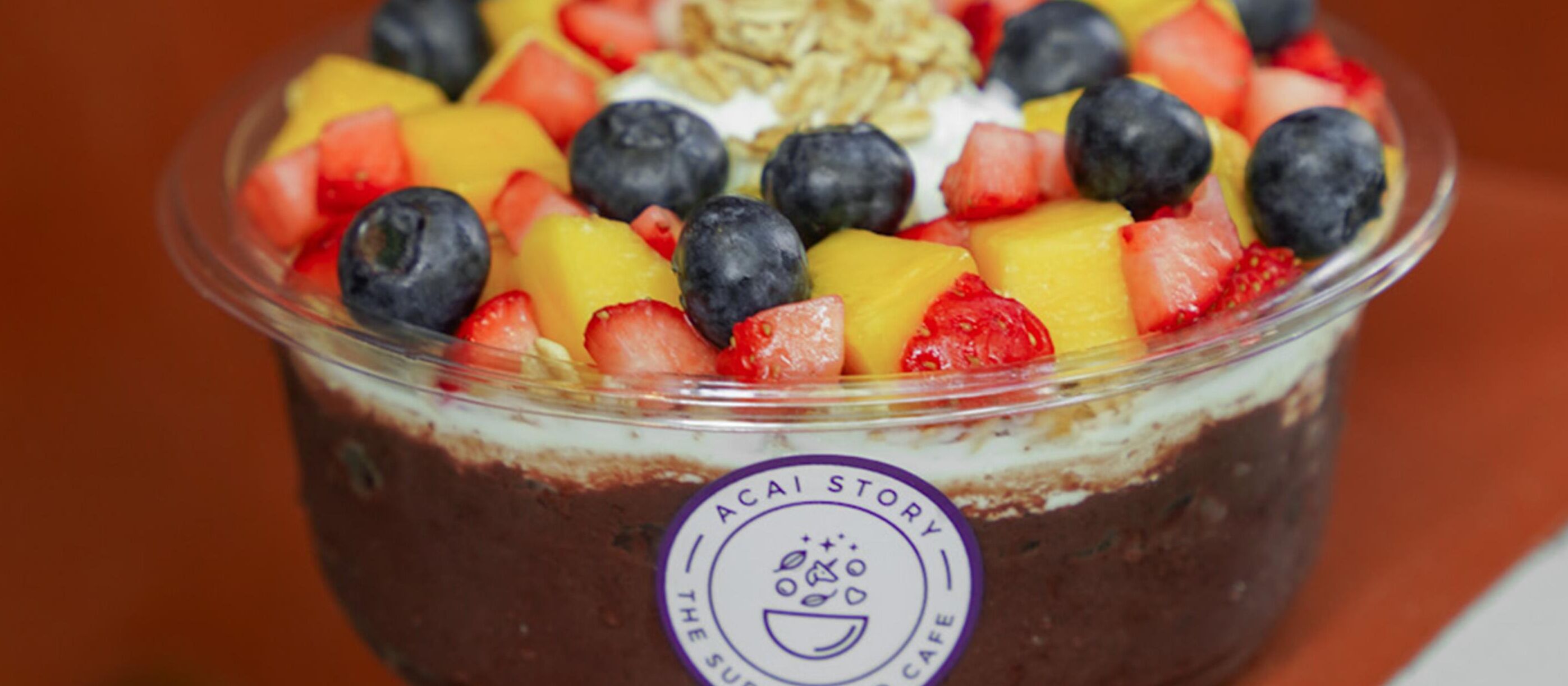 Un postre con la etiqueta que dice "ACAI STORY THE SUMMER CAFE".