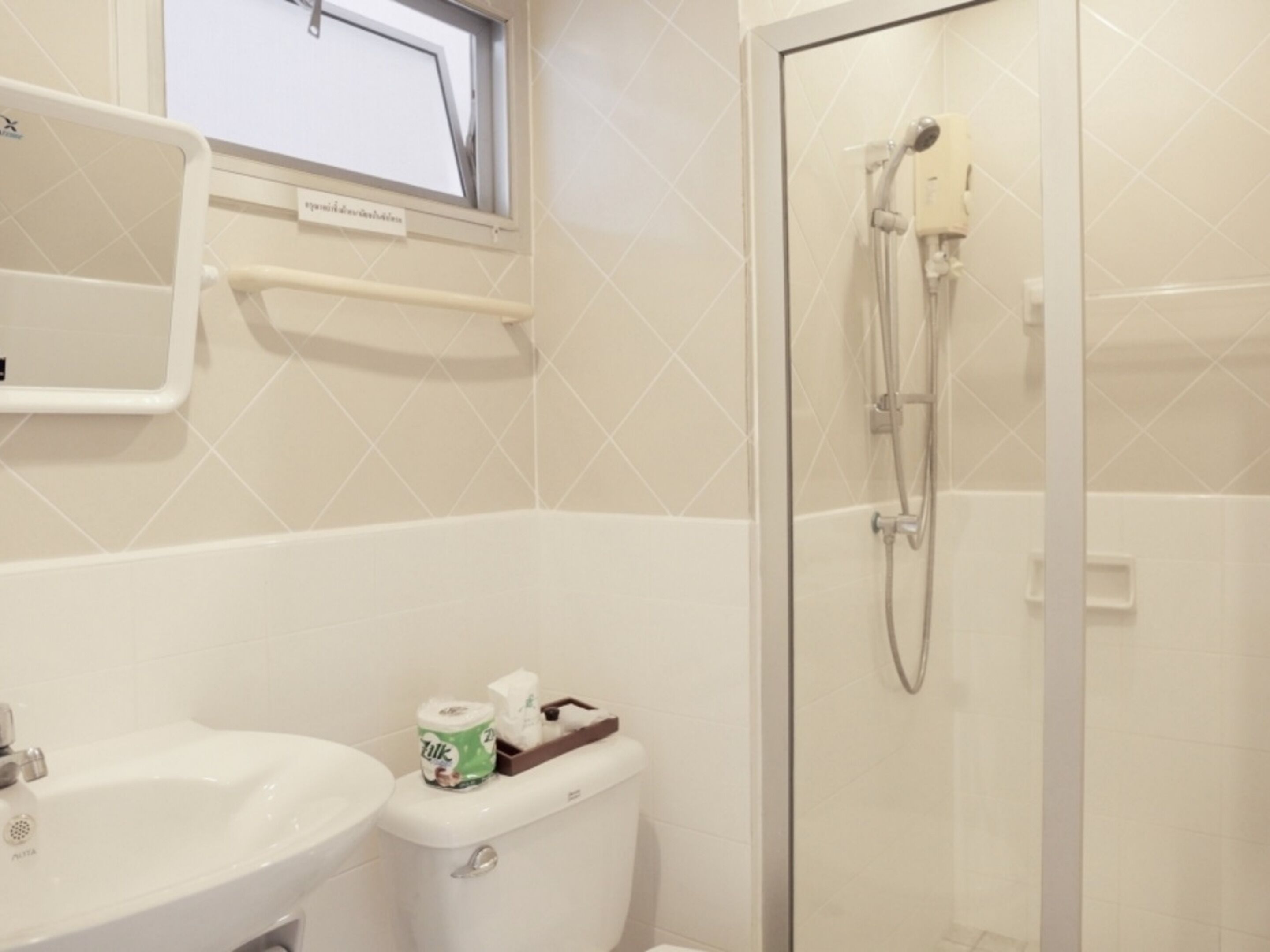 A bathroom with a toilet, sink, and shower.