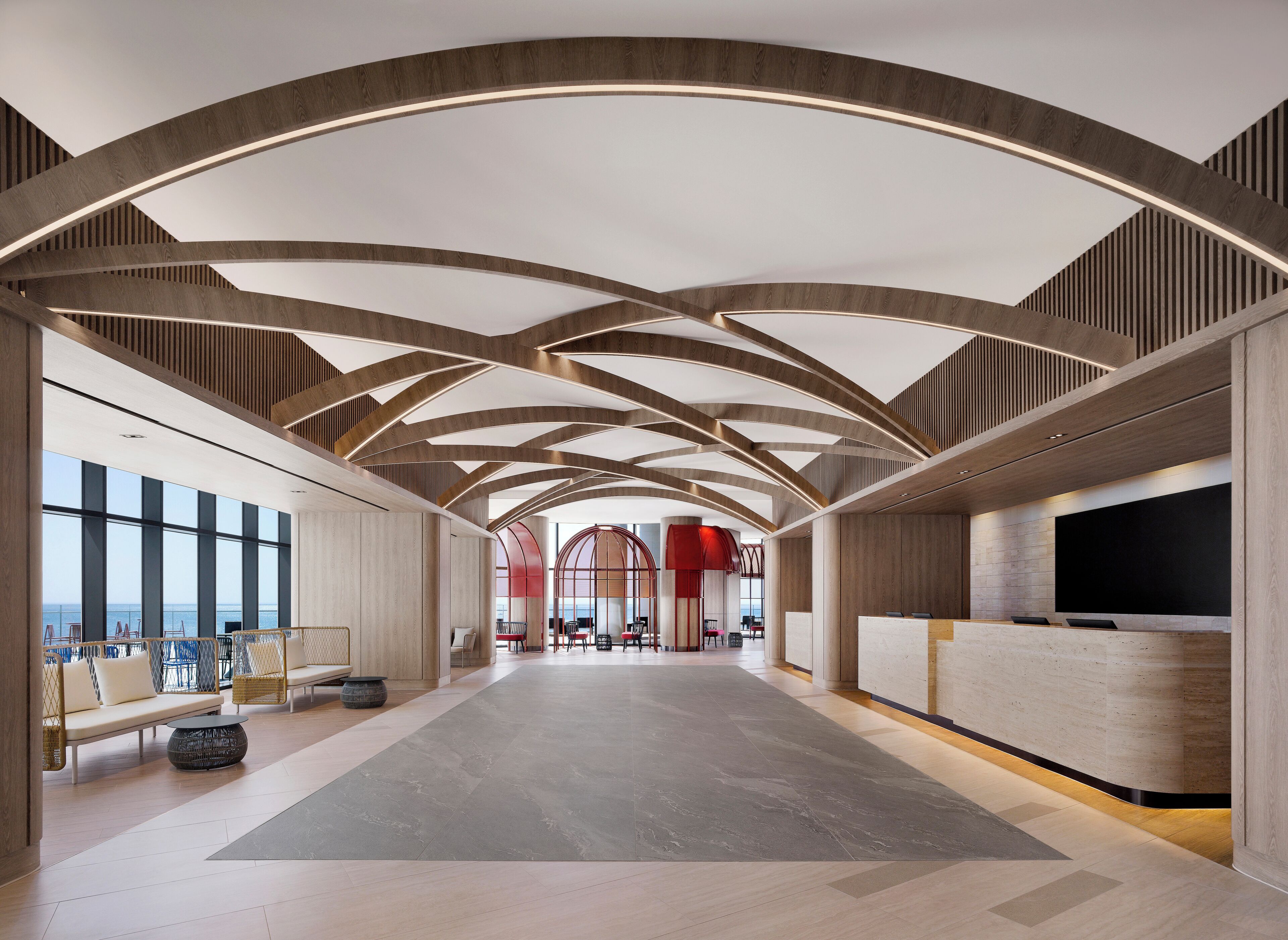 A spacious lobby with a high ceiling, modern seating, and a reception area.