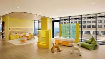 Kids can play and explore in this vibrant play area with a slide, seating, and city views.