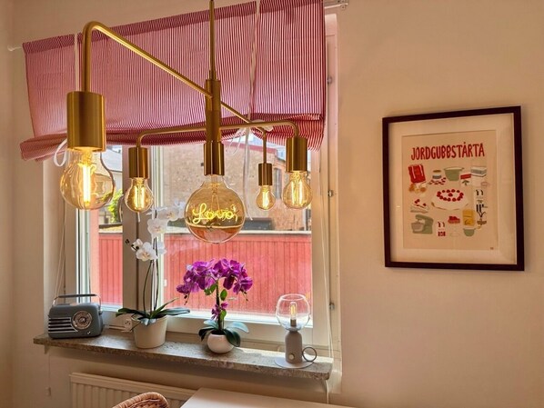 Una cocina con lámparas colgantes, una radio y un cuadro en la pared.