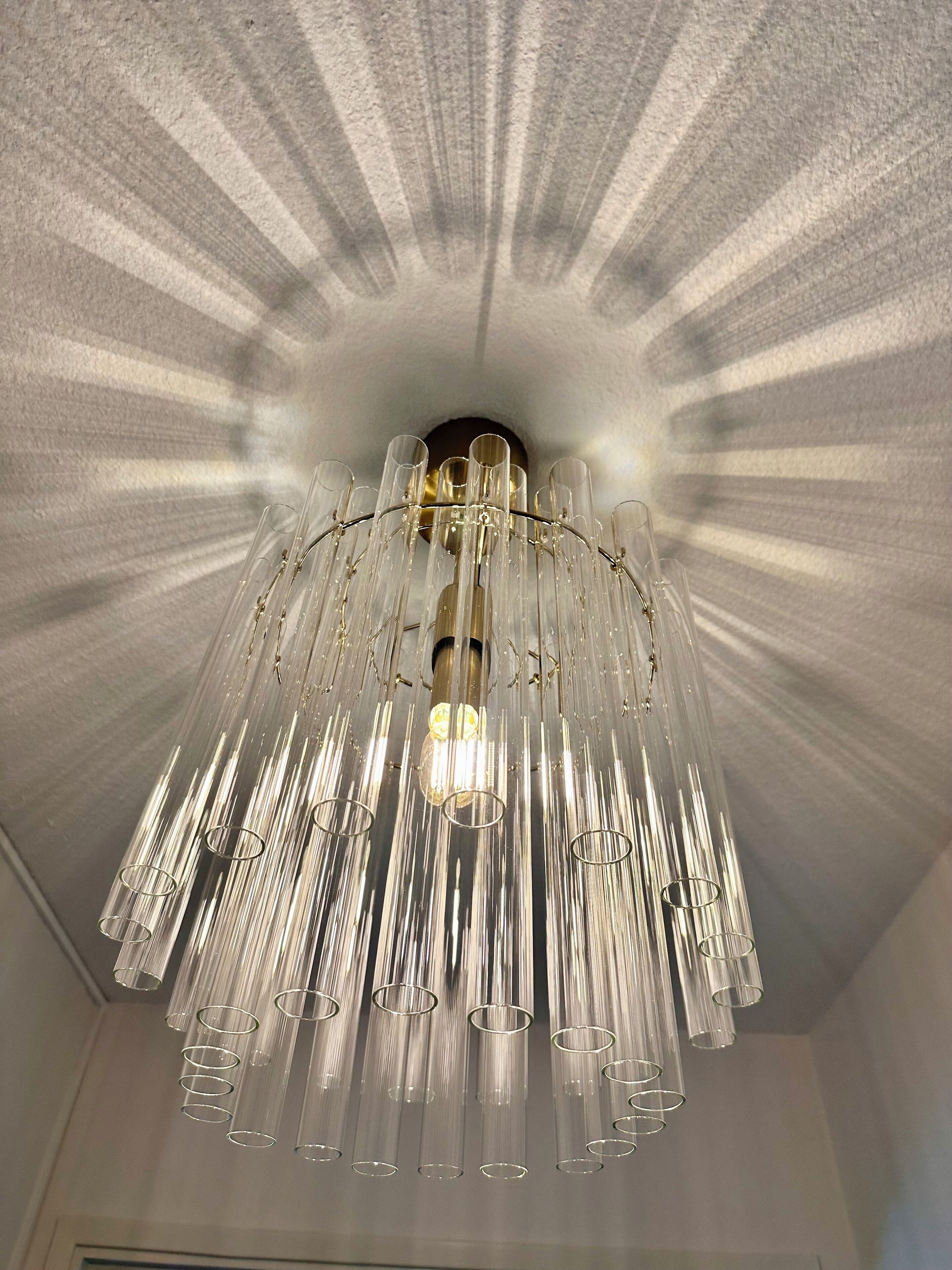 A chandelier with multiple glass tubes and a central light fixture.