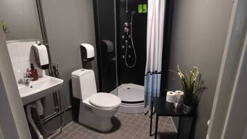 Ein kleines Badezimmer mit Toilette, Waschbecken und Dusche.
