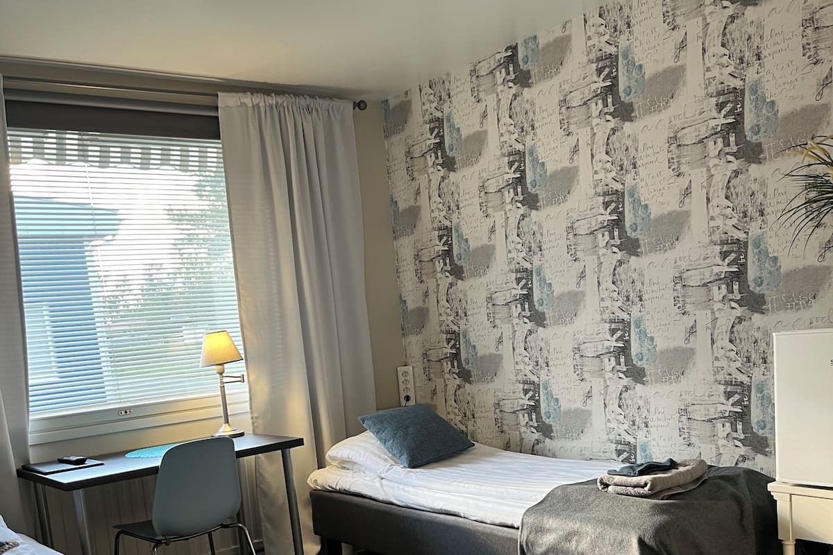 Un dormitorio con cama, escritorio y silla.