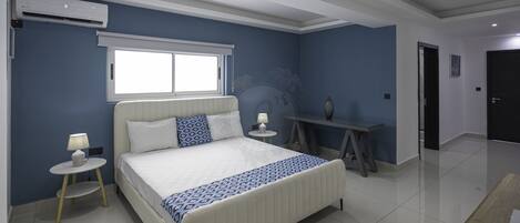 A bedroom with a bed, bedside tables, a lamp, a window, and a radiator.