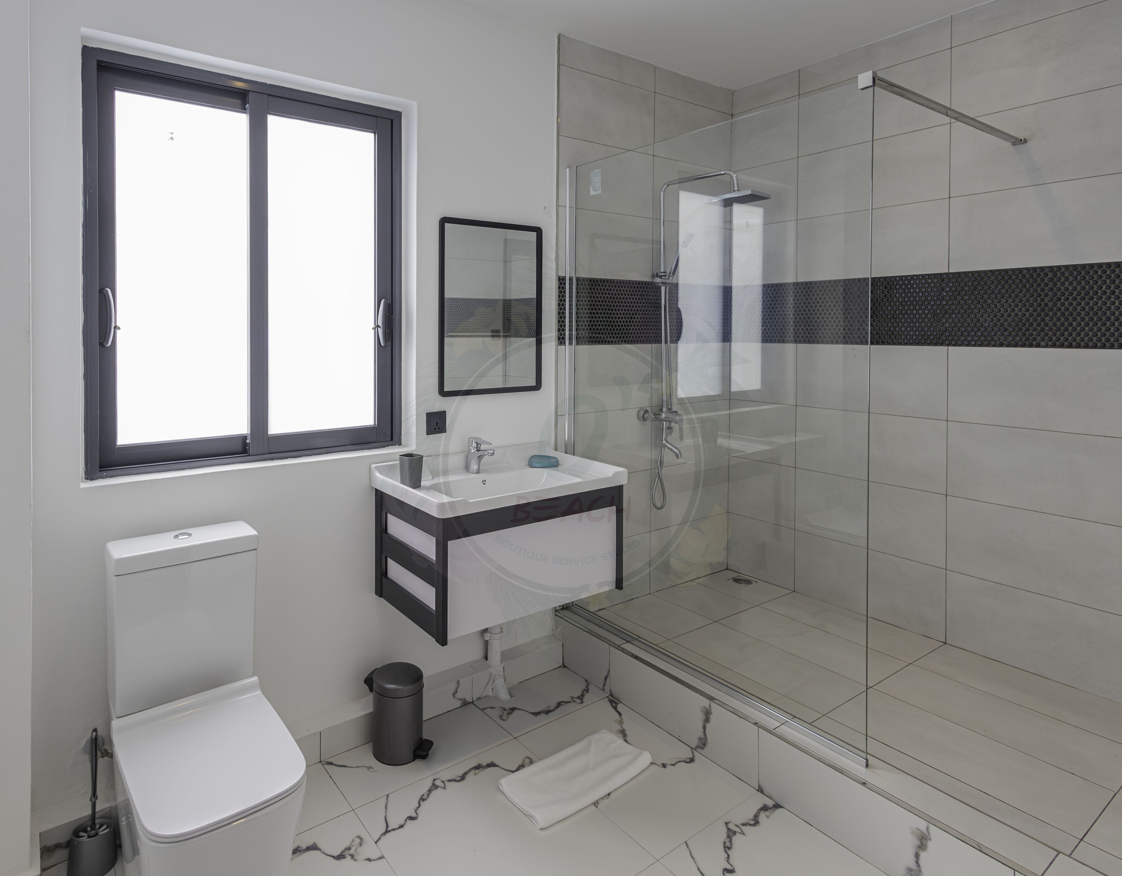 Un baño moderno con inodoro, lavamanos y ducha.