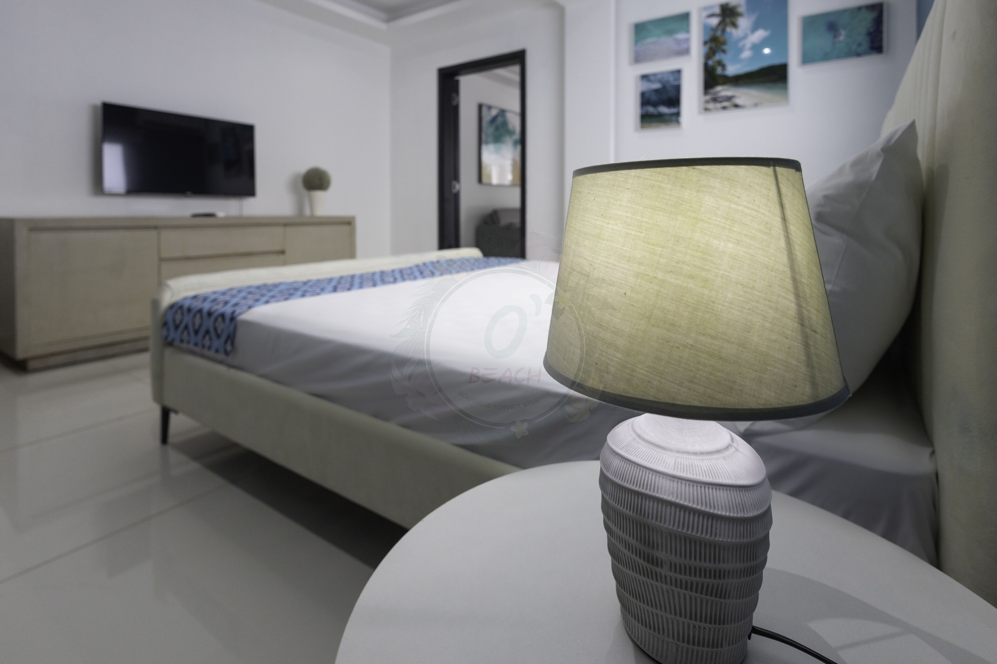 Ein modernes Hotelzimmer mit Bett, Nachttisch mit Lampe, Fernseher und Kleiderschrank.