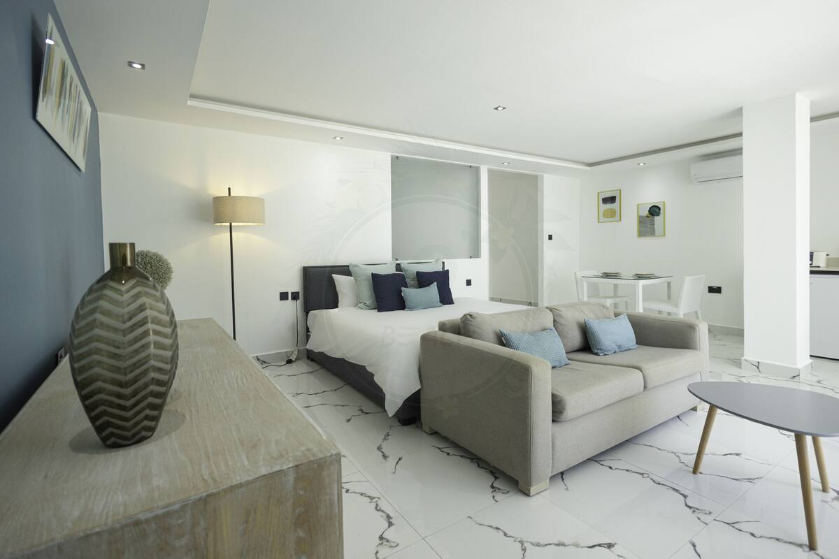 Ein modernes Hotelzimmer mit Bett, Sofa und einem kleinen Tisch.
