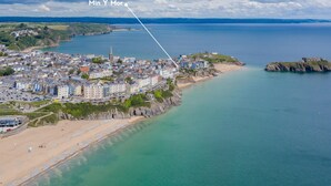 An aerial view of a coastal town with a prominent church, a beach, and a rocky outcrop. - Min Y Mor - Breathtaking Sea Views (Tenby)