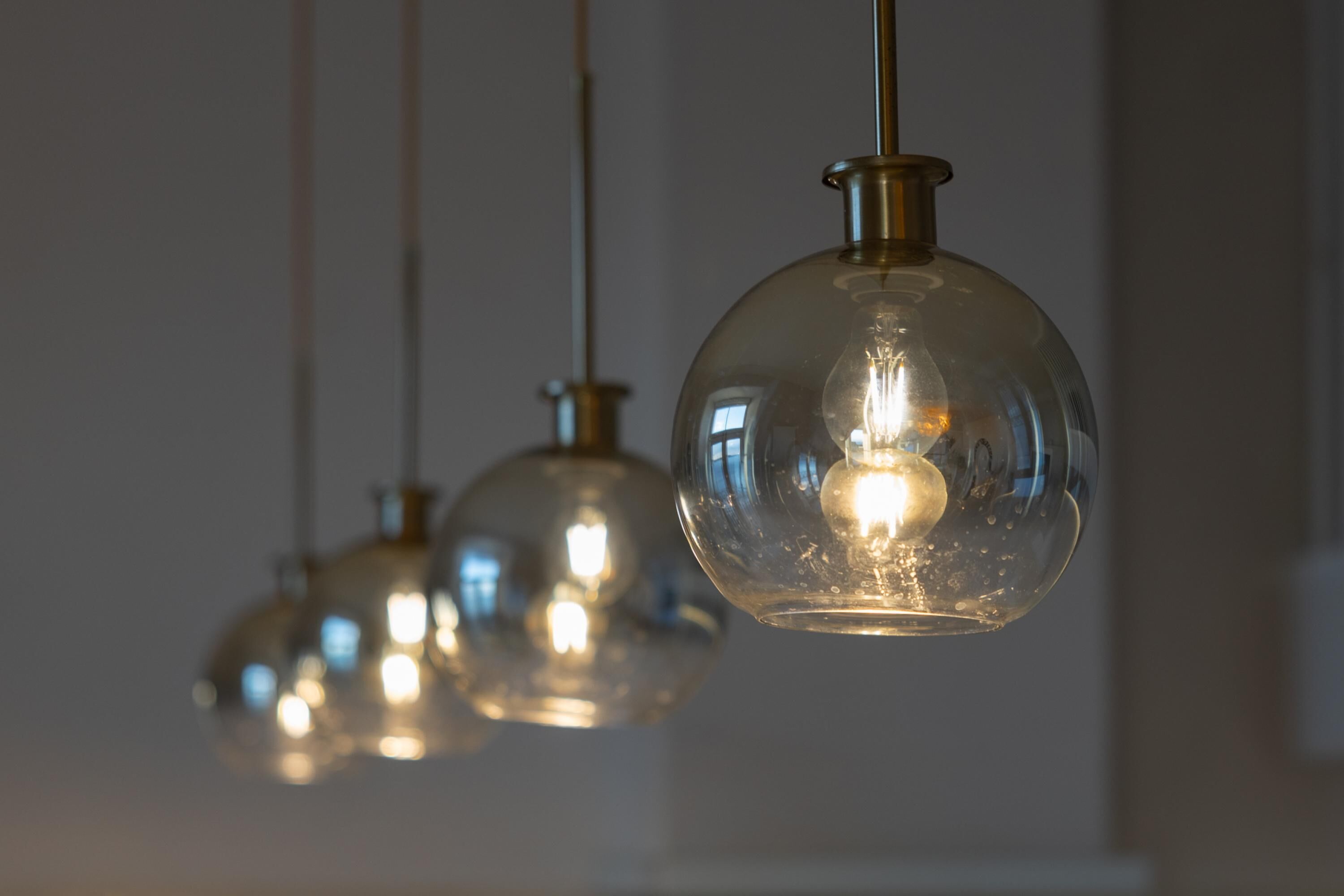 Three hanging pendant lights with clear glass shades and visible bulbs.