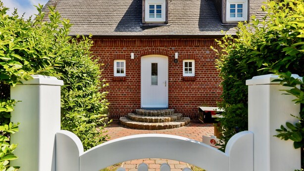 A brick house with a white door and a small porch.