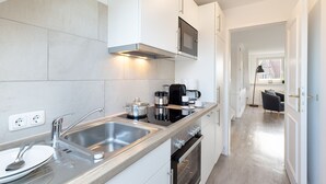 Una cocina moderna con electrodomésticos de acero inoxidable, horno empotrado y un lavamanos grande.