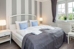 Relax in a serene bedroom with a large bed, bedside tables, and a window overlooking lush greenery.