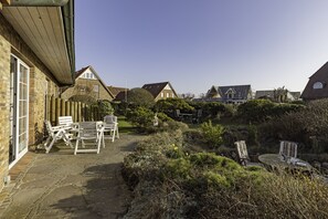 Relax in a serene garden setting with a patio and seating area.