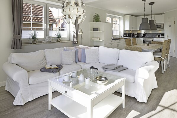 Relax in this stylish living space with a comfortable sofa, coffee table, and adjacent kitchen.