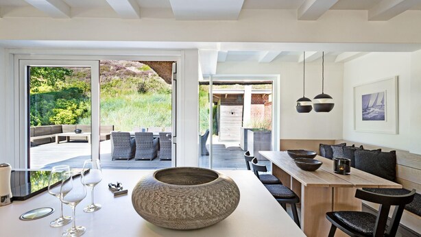 A modern kitchen with a large island, seating area, and a view of the outdoors.