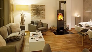 Una sala de estar acogedora con chimenea, un sofá, una mesa de centro y un comedor.