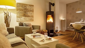 Una sala de estar acogedora con chimenea, asientos cómodos y un comedor.