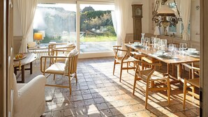 Comedor con una mesa grande dispuesta para seis personas, rodeado de sillas de madera.