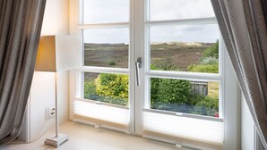 Ein Zimmer mit großem Fenster und Blick auf eine natürliche Landschaft.