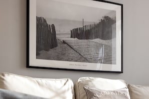 A framed photograph of a beach pathway with wooden barriers, captioned "Cédric Porchez - Dunes".
