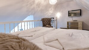 Une chambre à coucher avec un lit, une chaise, une télévision et un bureau.
