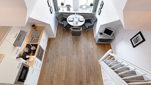 Une cuisine moderne avec un coin repas, un plancher en bois et un escalier.