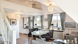 Ein geräumiges Loft mit Essbereich, einer Couch und einem Fernseher.