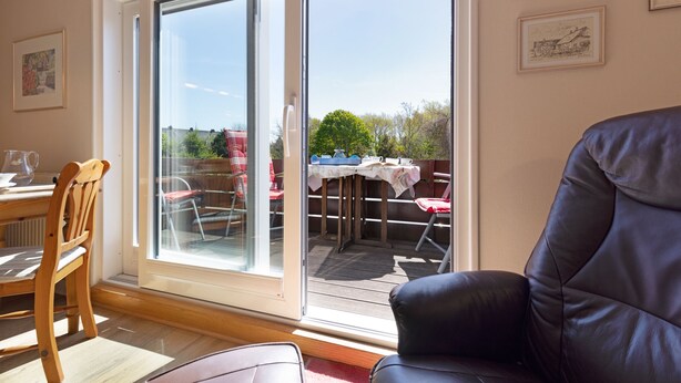 Una habitación con puerta de vidrio corrediza que da a un patio al aire libre.