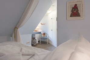 Ett sovrum med en säng, ett skrivbord och en stol.