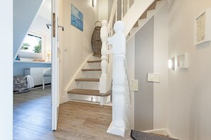 A staircase with white balusters and wooden steps leading to a landing. - Herzlich Willkommen im Ferienhaus Fischers Koje (List)