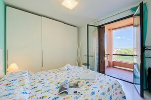Un dormitorio con cama, ventana y balcón.