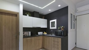 A modern kitchen with wooden cabinets, a microwave, a sink, and a window. - Marnis10 3rd (Athens)