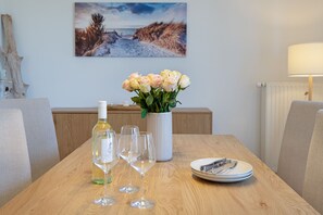 Ein Esstisch mit Blumen, Weingläsern und Tellern.