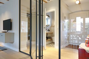 Enjoy a minimalist bathroom with a flat-screen TV and ample storage.
