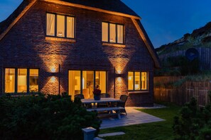 A brick house with a large patio and a dining table. - Herzlich Willkommen im Luxus-ferienhaus Düünkieker "ankommen, Wohlfühlen!" (List)