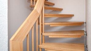 Una escalera de madera con varios peldaños y barandillas.