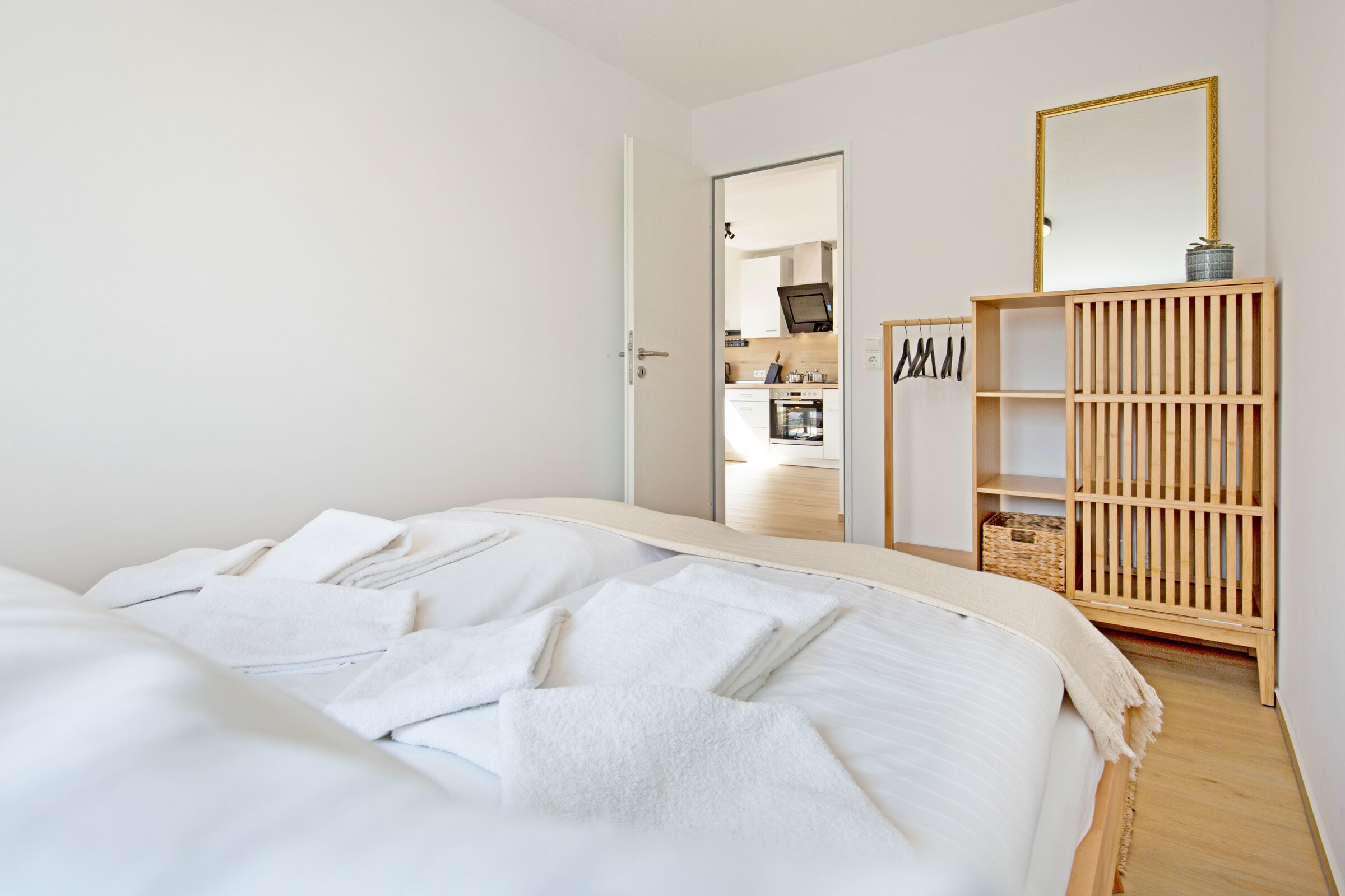 Une chambre à coucher avec un lit, une armoire en bois et un miroir.