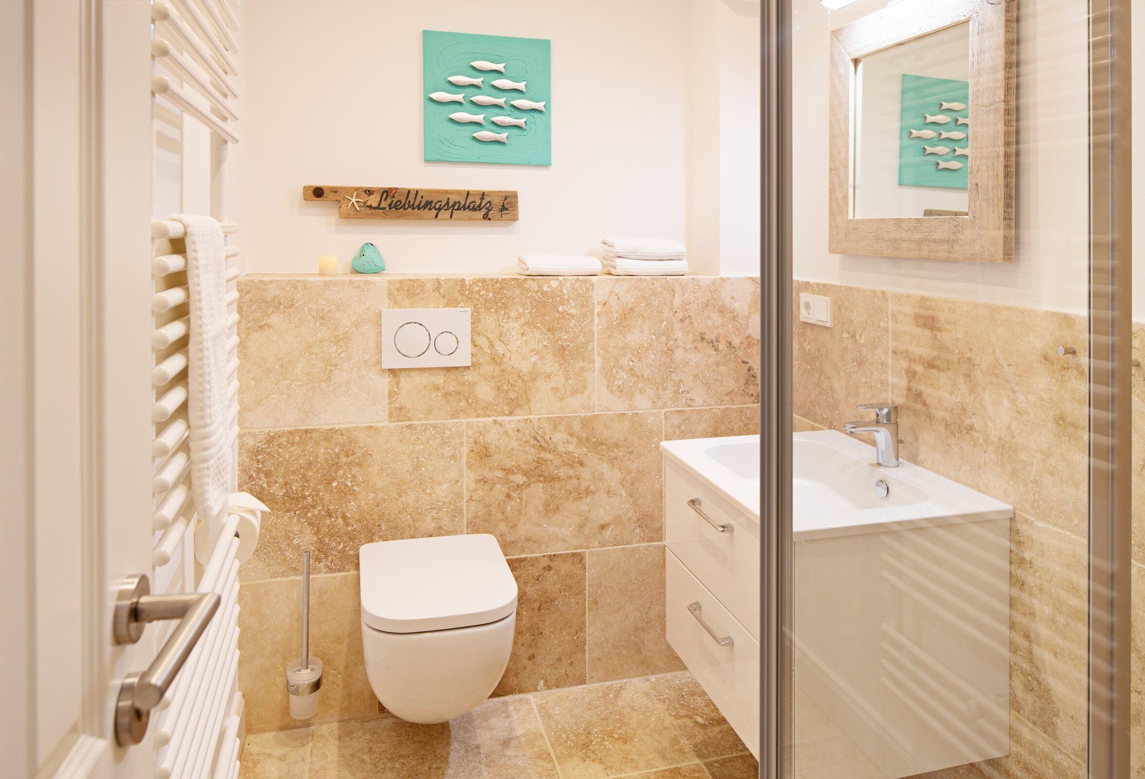 Ein Badezimmer mit Toilette, Waschbecken und Handtuchhalter.