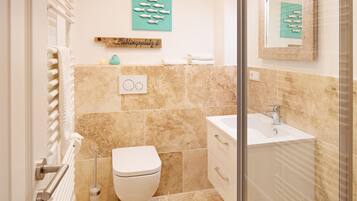 Ein Badezimmer mit Toilette, Waschbecken und Handtuchhalter.