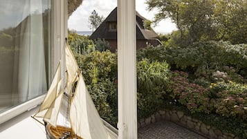 Un modelo de velero en una habitación con vistas a un jardín y una casa.
