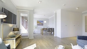 Ein modernes Wohnzimmer mit einer Couch, einem Couchtisch und einem Essbereich mit Tisch und Stühlen.